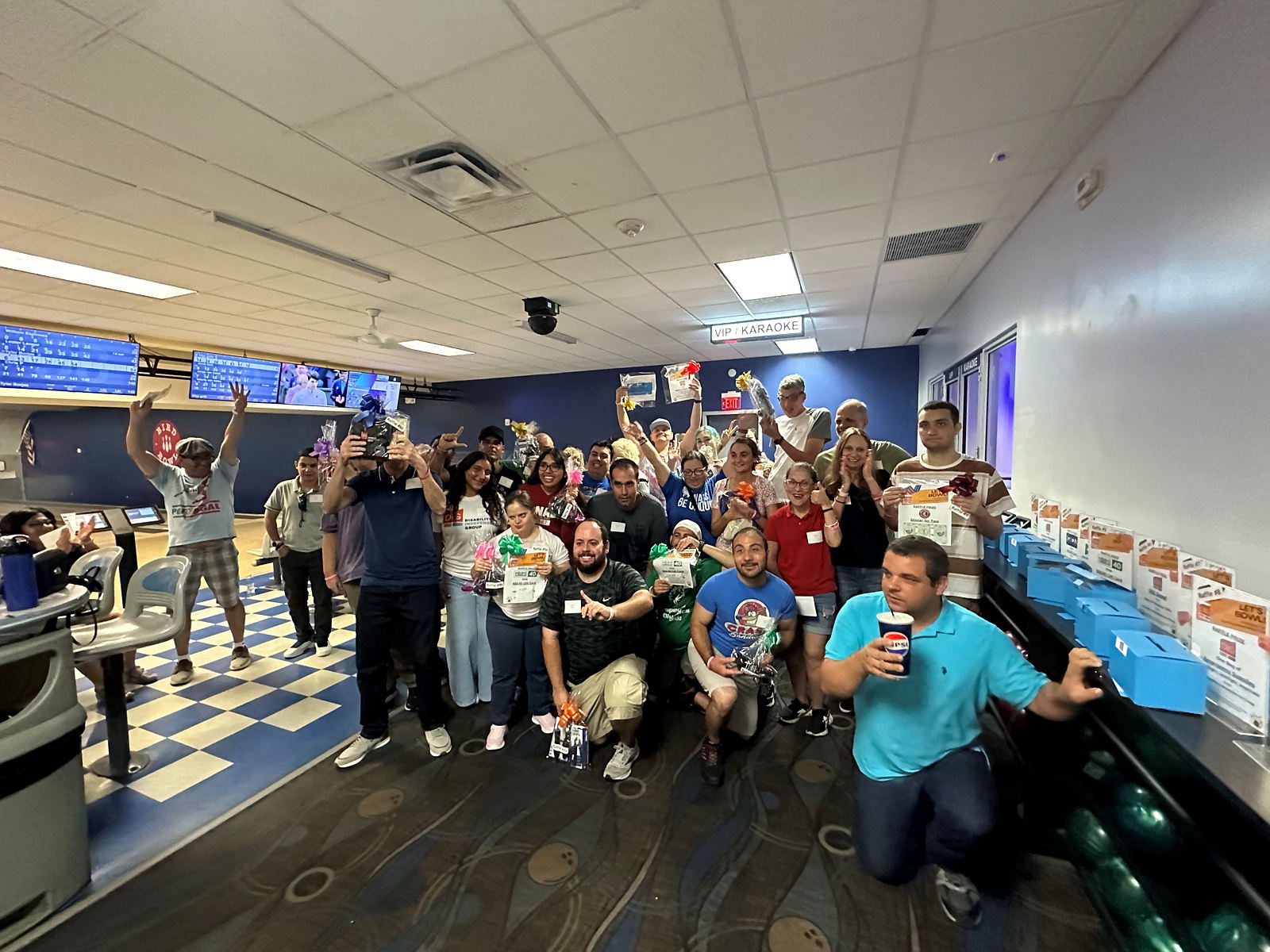 A group of people at the bowling alley smiling at the camera