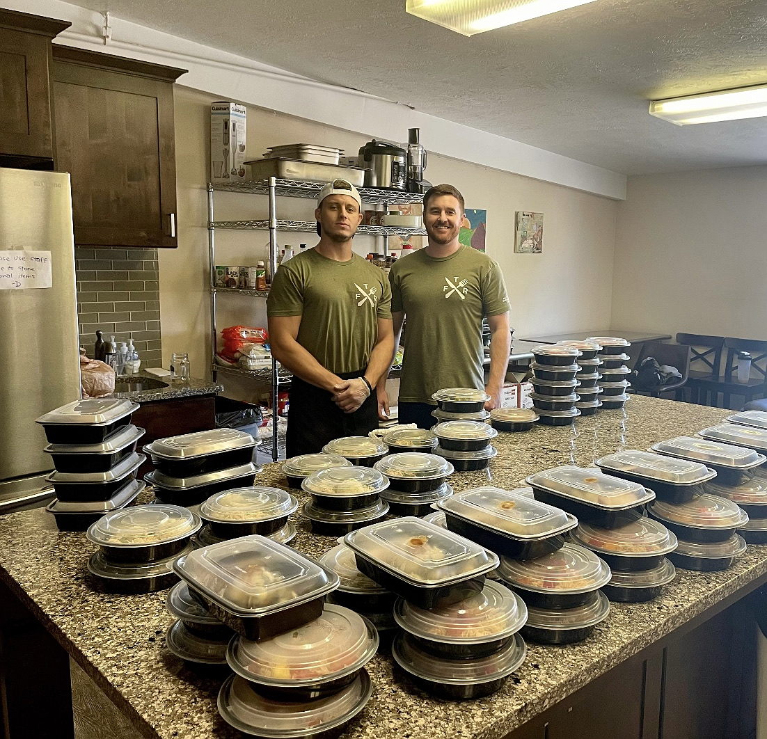 Randy and Bryan cooking in the kitchen, preparing weekly community meal-prep meals.