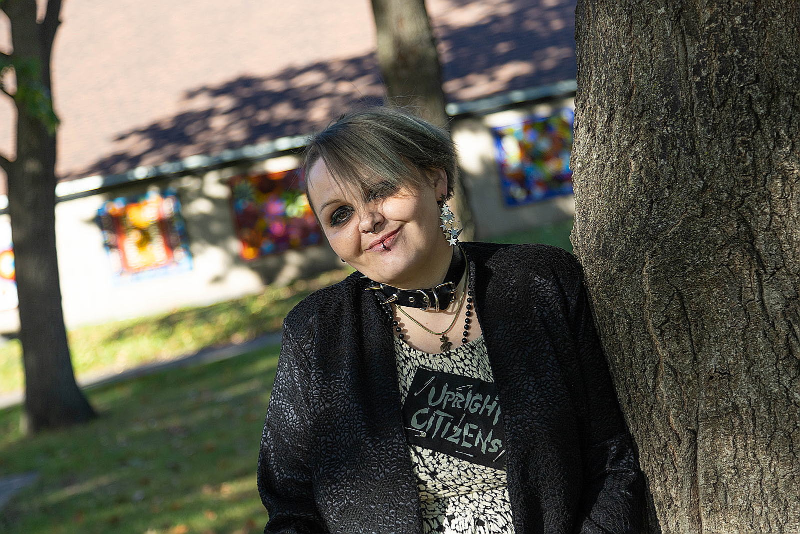 A person leaning against a treeDescription automatically generated