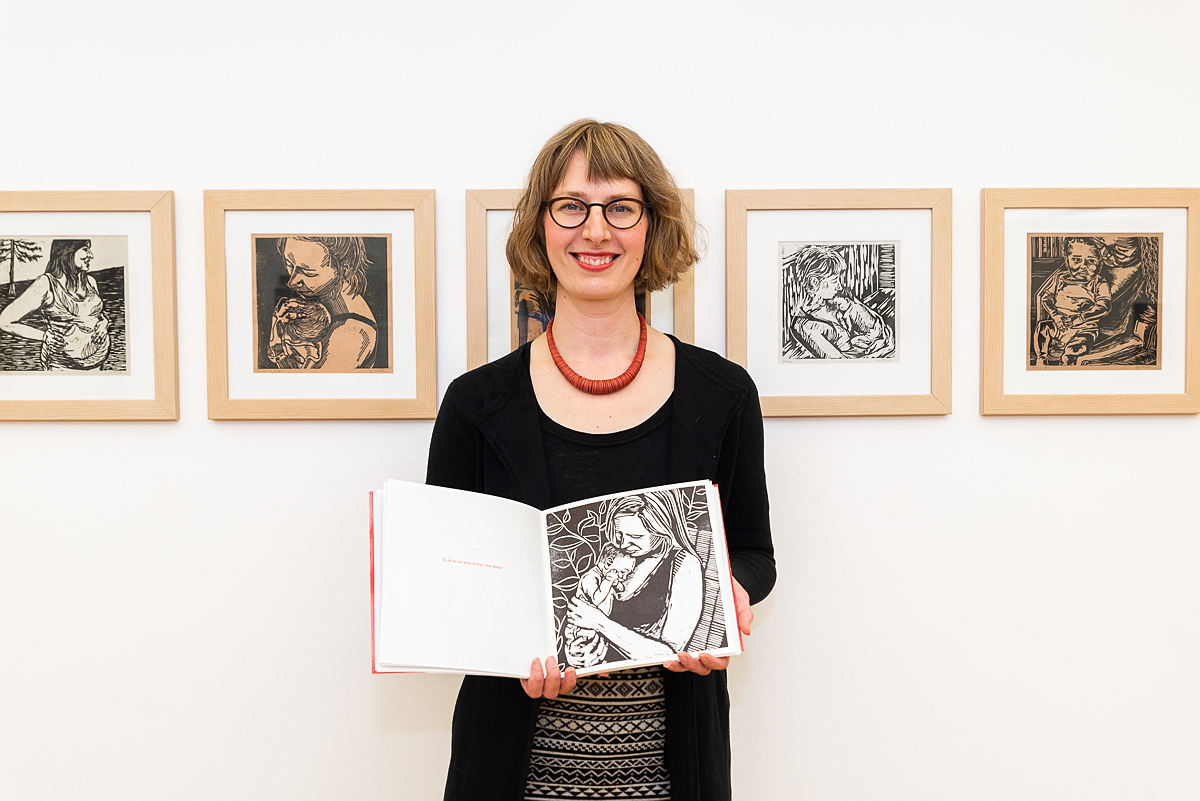 Multiple guests browse through a zine display set up in the gallery.