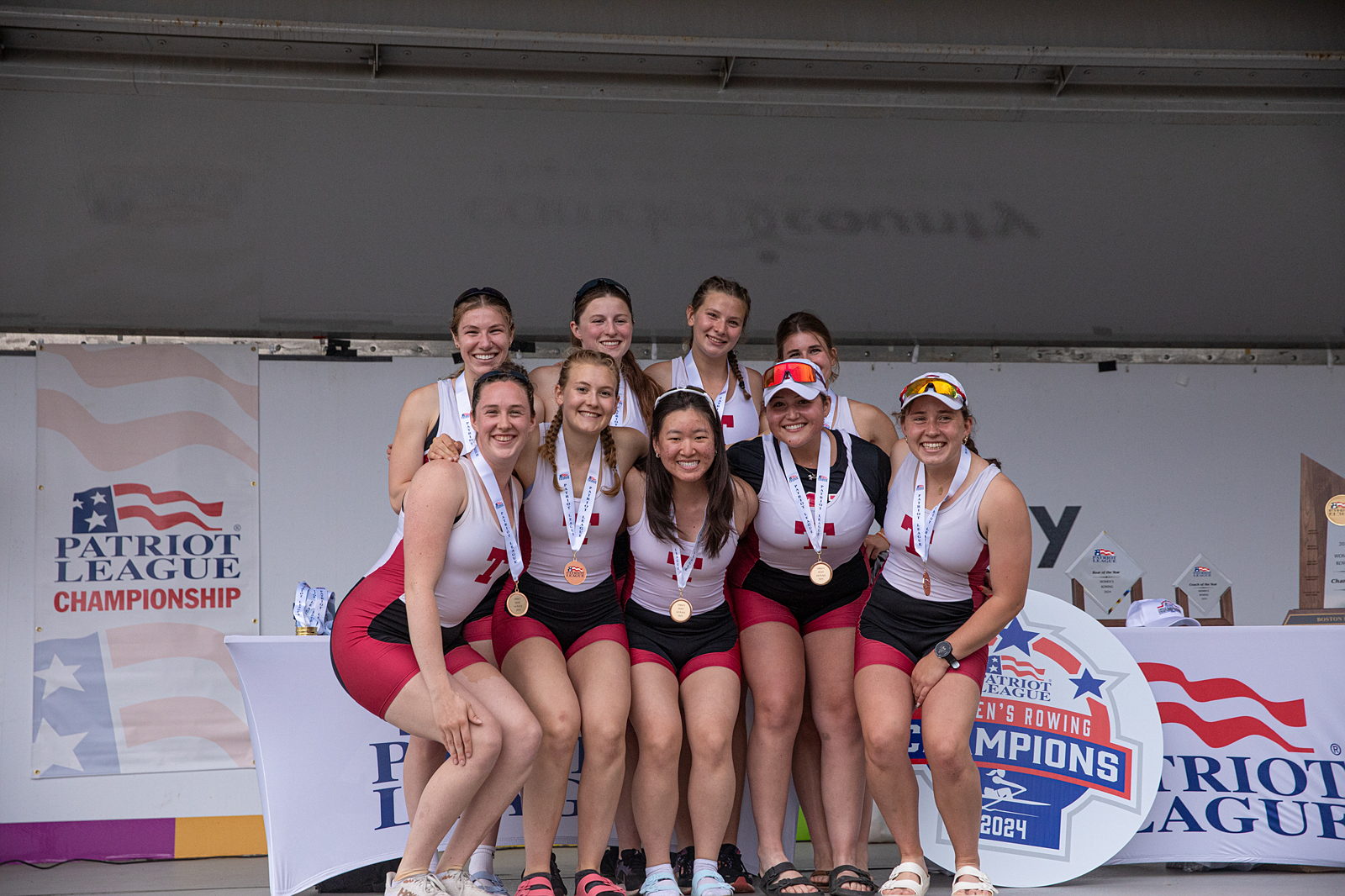 A group of athletes pose with their medals at the Patriots League Championship