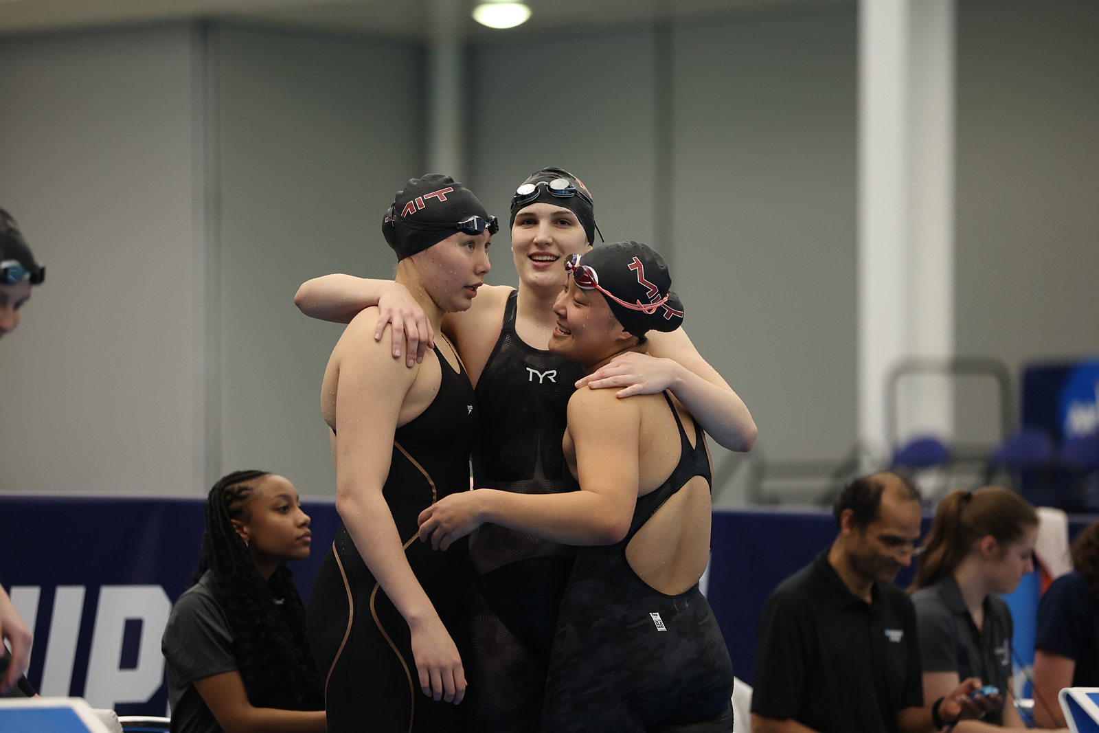 Three swimmers group hug