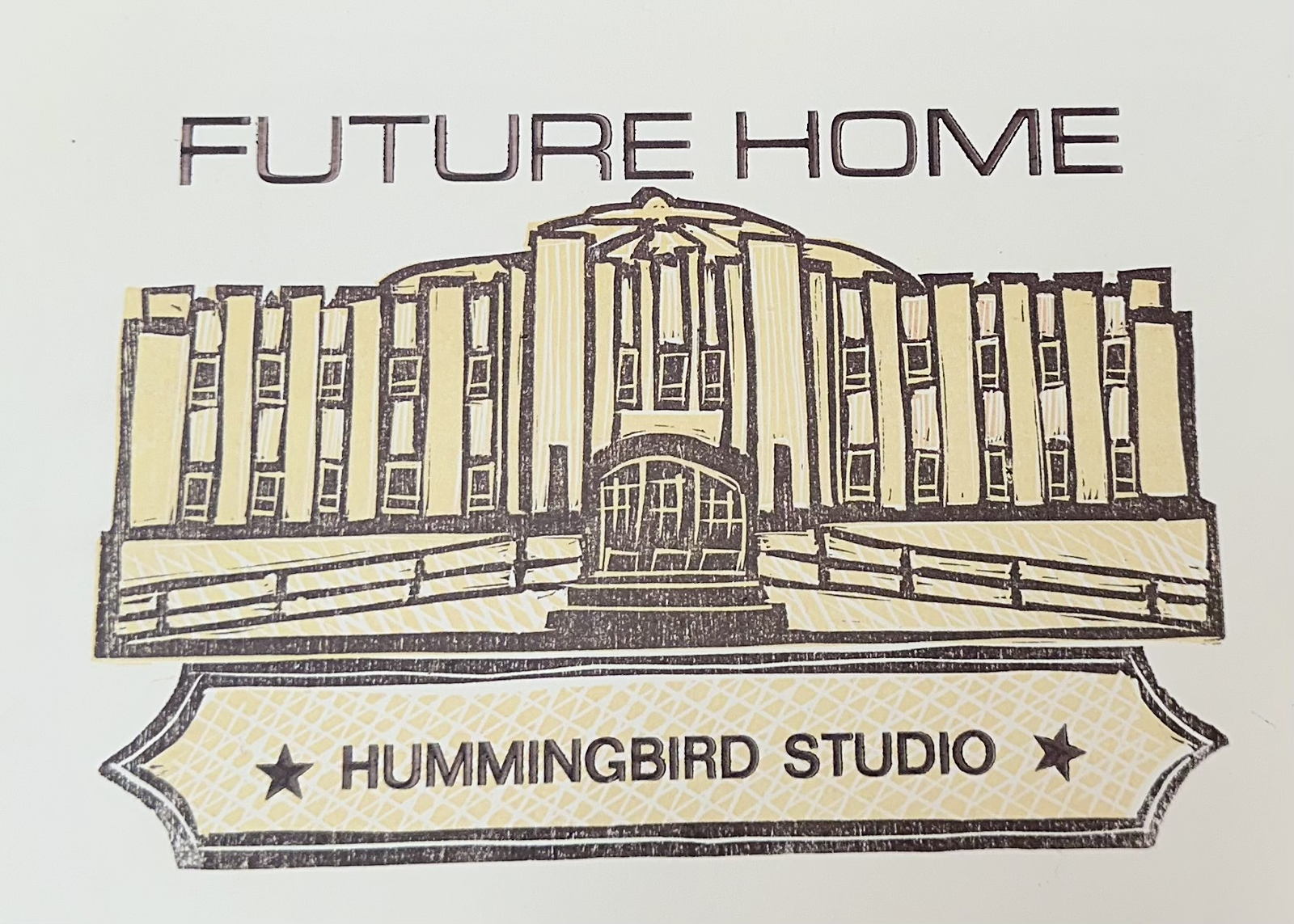 Handmade print by artist Kitty Koppelman from Community Print, depicting the Olympia Armory that reads: Future Home and underneath hummingbird studio. Printed in yellow and brown. 
