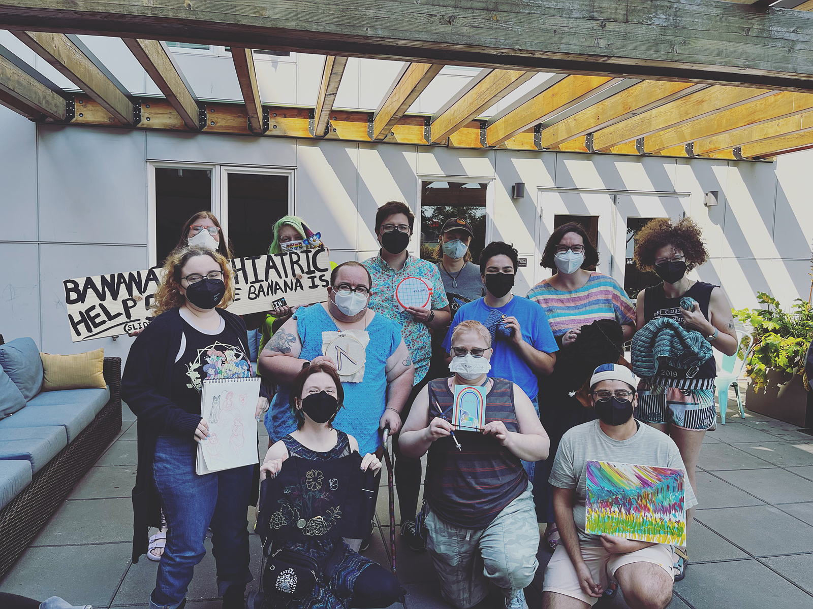 Crafternoon: 11 scouts holding up craft projects like paintings, cross-stitch, and knitting