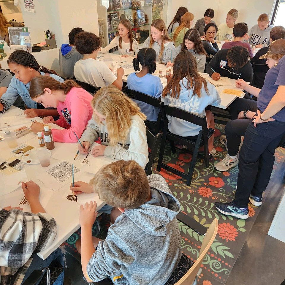 Group of middle school students learning how to faux finish on a school field trip.