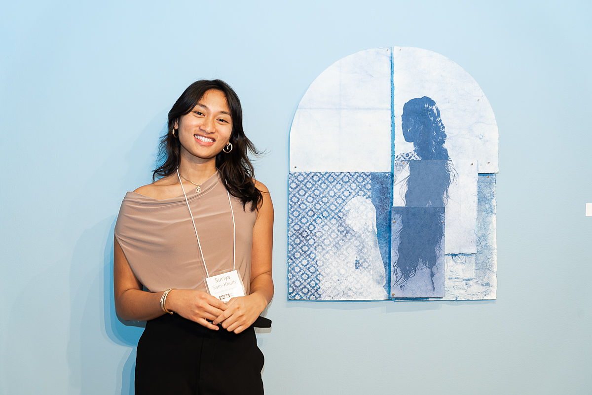 Guest at the 2022 Jerome Book Arts Residency reception looking at three works of art.