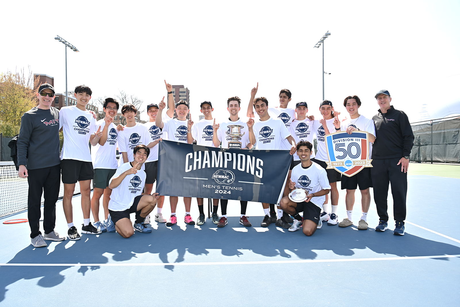 Men's tennis team with 2024 championship banner