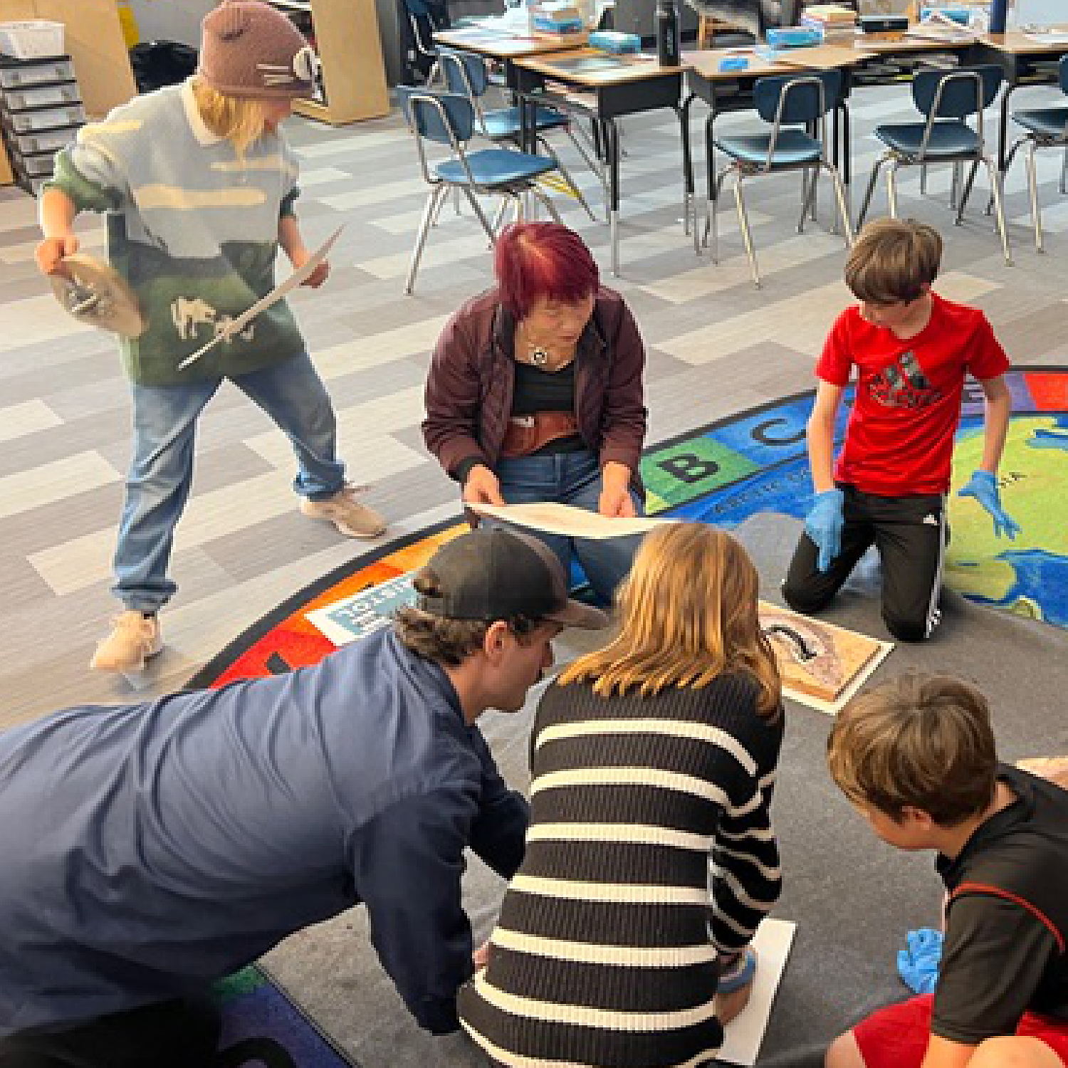 A local artist guides students in a salmonid-themed art project.