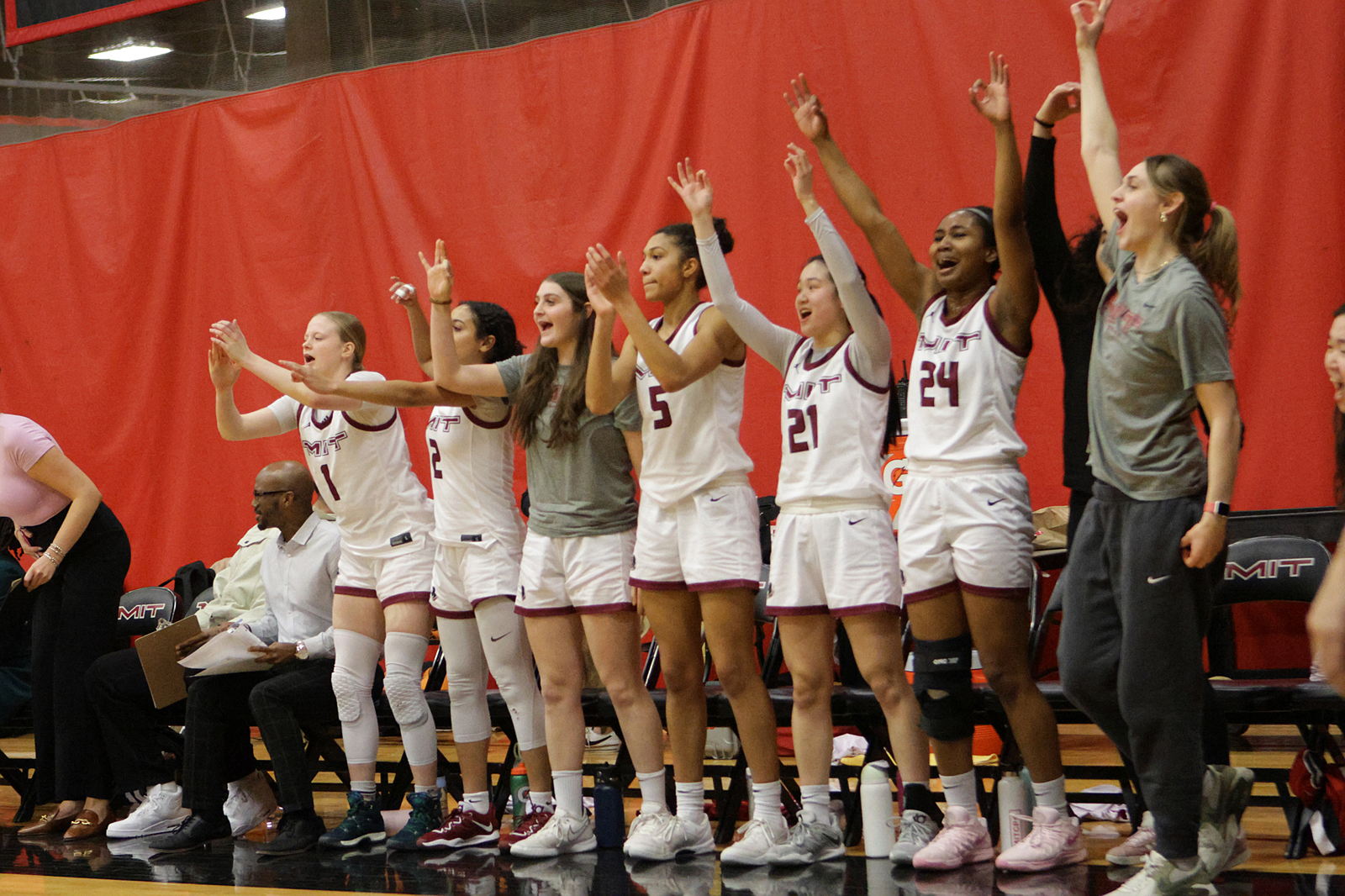 Women's Basketball team members cheer courtside