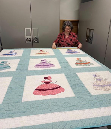 A person standing in front of a quilt AI-generated content may be incorrect.