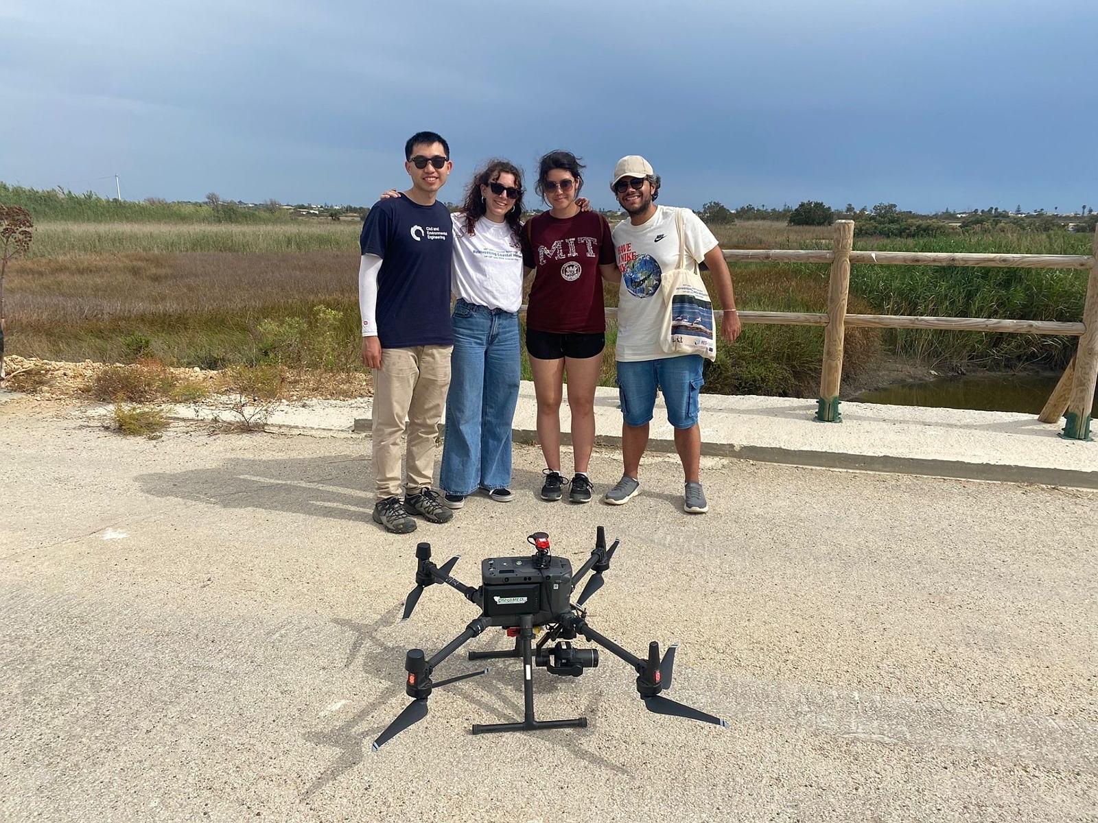 Students standing with drone