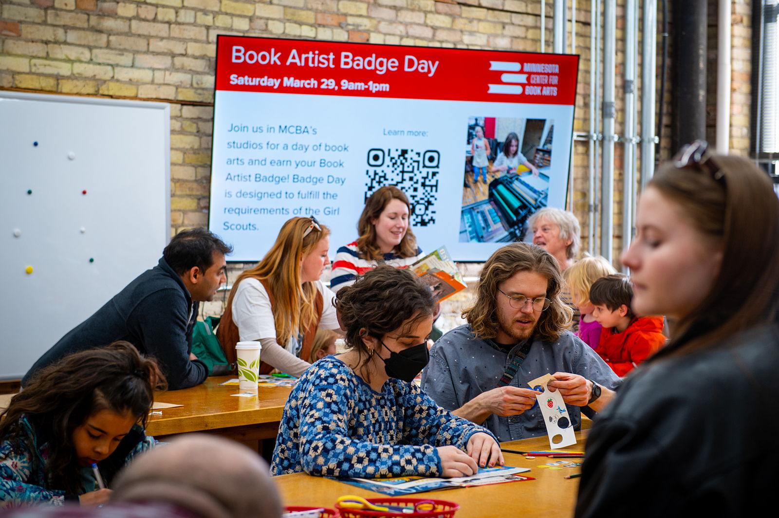 Guest at the 2022 Jerome Book Arts Residency reception looking at three works of art.