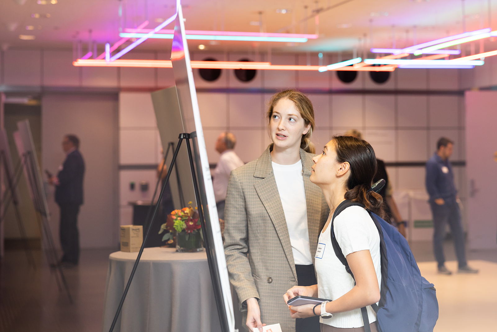 Two women examine of poster board of information