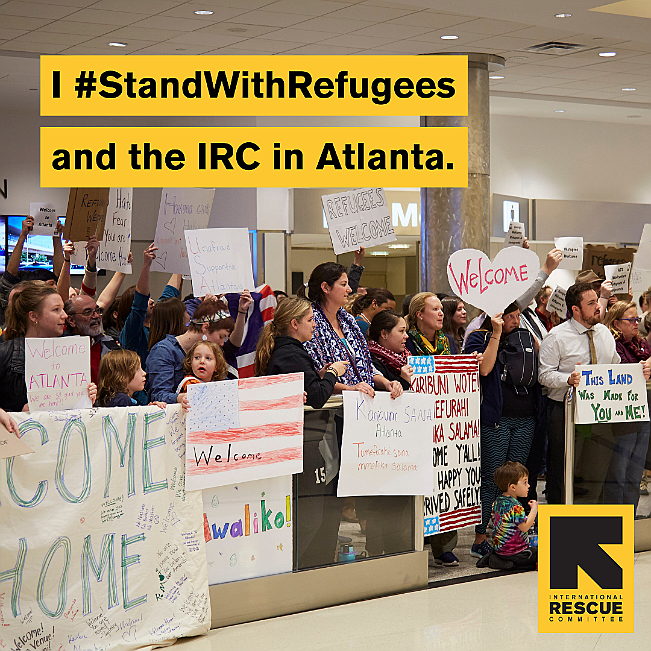 A group of people holding signs 
Description automatically generated