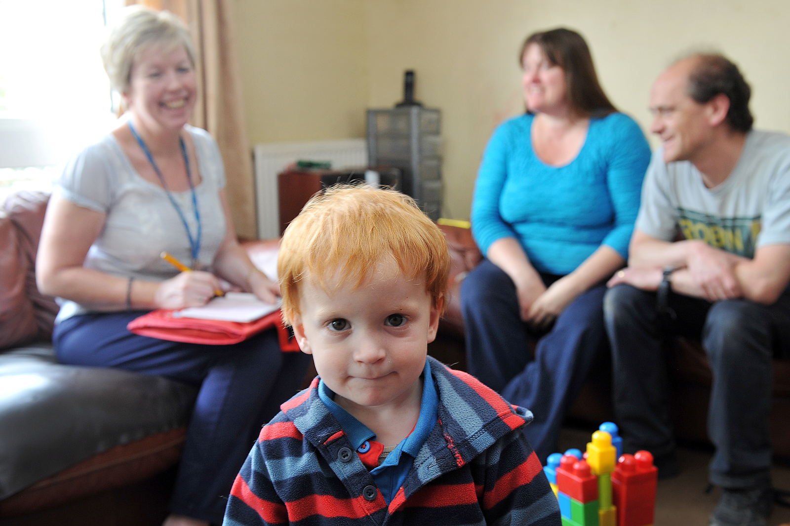 Young boy in foreground. Three adults behind.