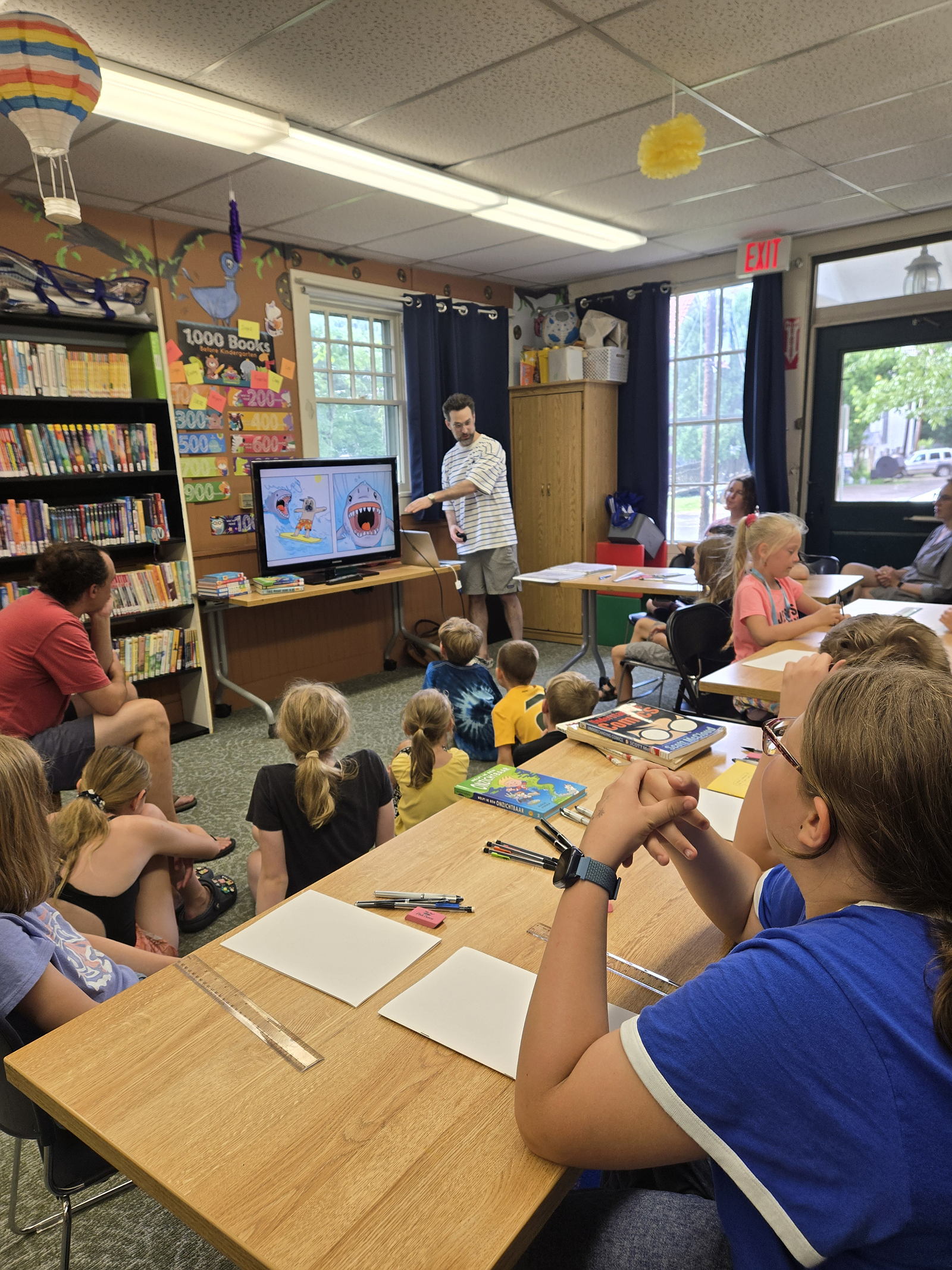 Group of children and teens listening to workshop presenter.