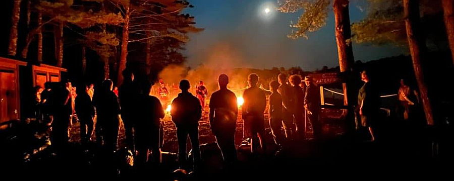 Scouts gathered around a campfire outdoors