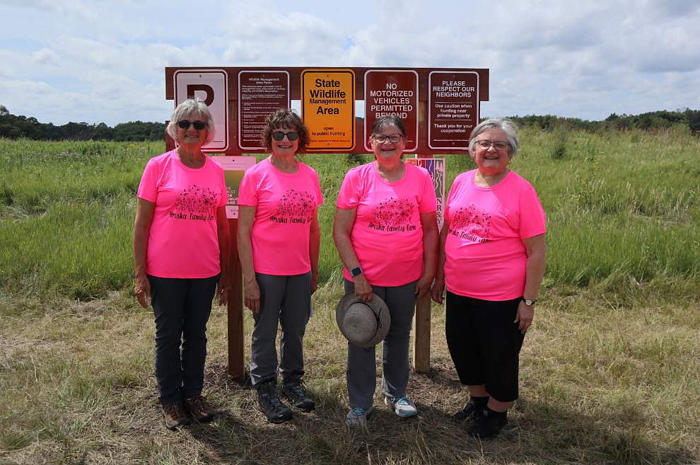 A photo of the Hruska sisters next to the new signage at Horseshoe Lake WMA.