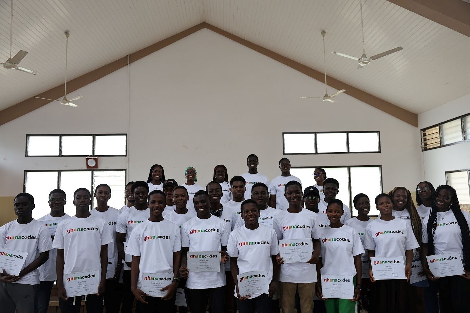 Staff and students wearing GhanaCodes shirts stand together smiling