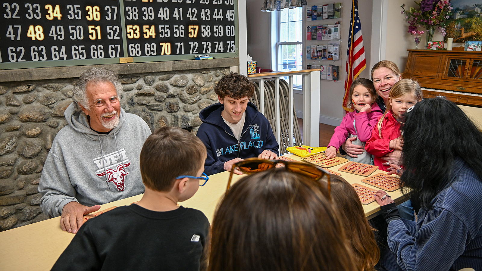 A group of multi-generational residents playing Bingo in the community center